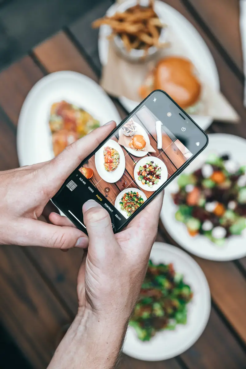 Žmogus telefonu fotografuoja maistą lėkštėje - AI atpažįsta produktus iš nuotraukos